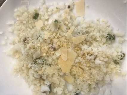 Bed of Cauliflower Rice, with asparagus, salt, pepper and shaved Asiago cheese